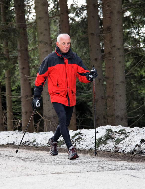 älterer Mann beim Nordic Walking